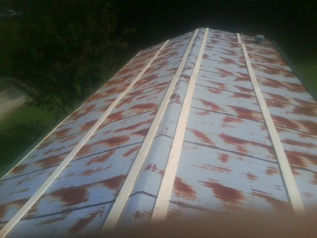 Rusted metal roof panels with new wood purlins before replacement — Storm Damage Roof Repair in Streetsboro by Roofing Brothers