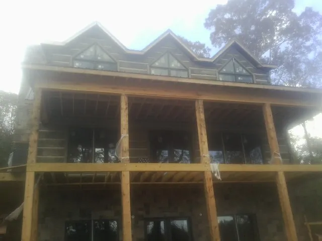 Dormers and porch framing on a large log home under construction — Roof Coating work by our crew in Streetsboro