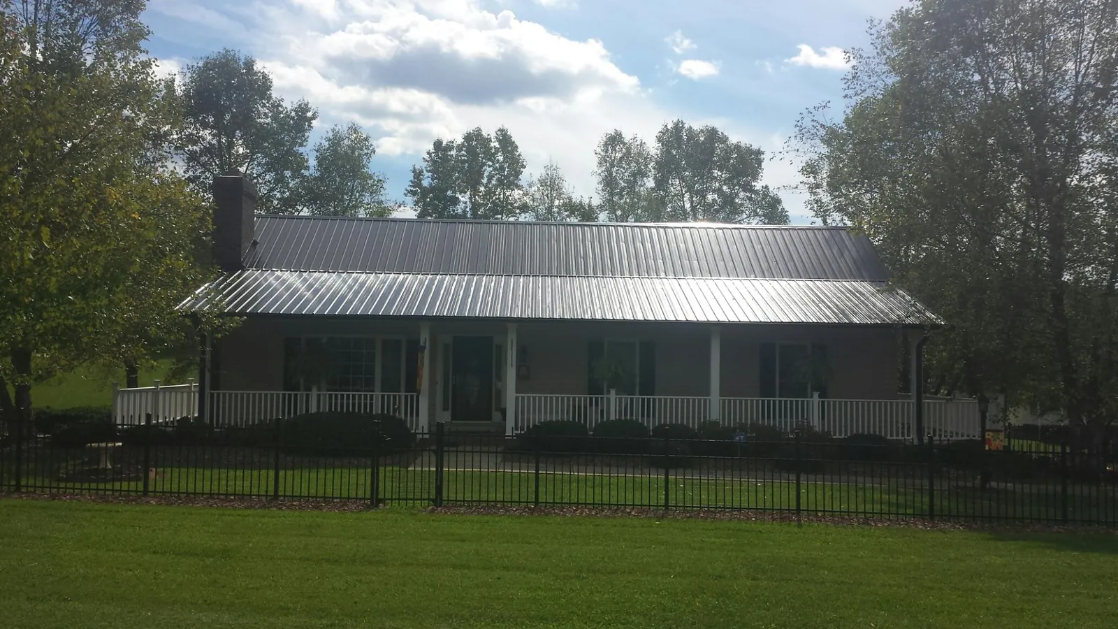 Gray metal roof on a brick ranch with a full width front porch — Gutter Guard Installation work by our crew in Streetsboro