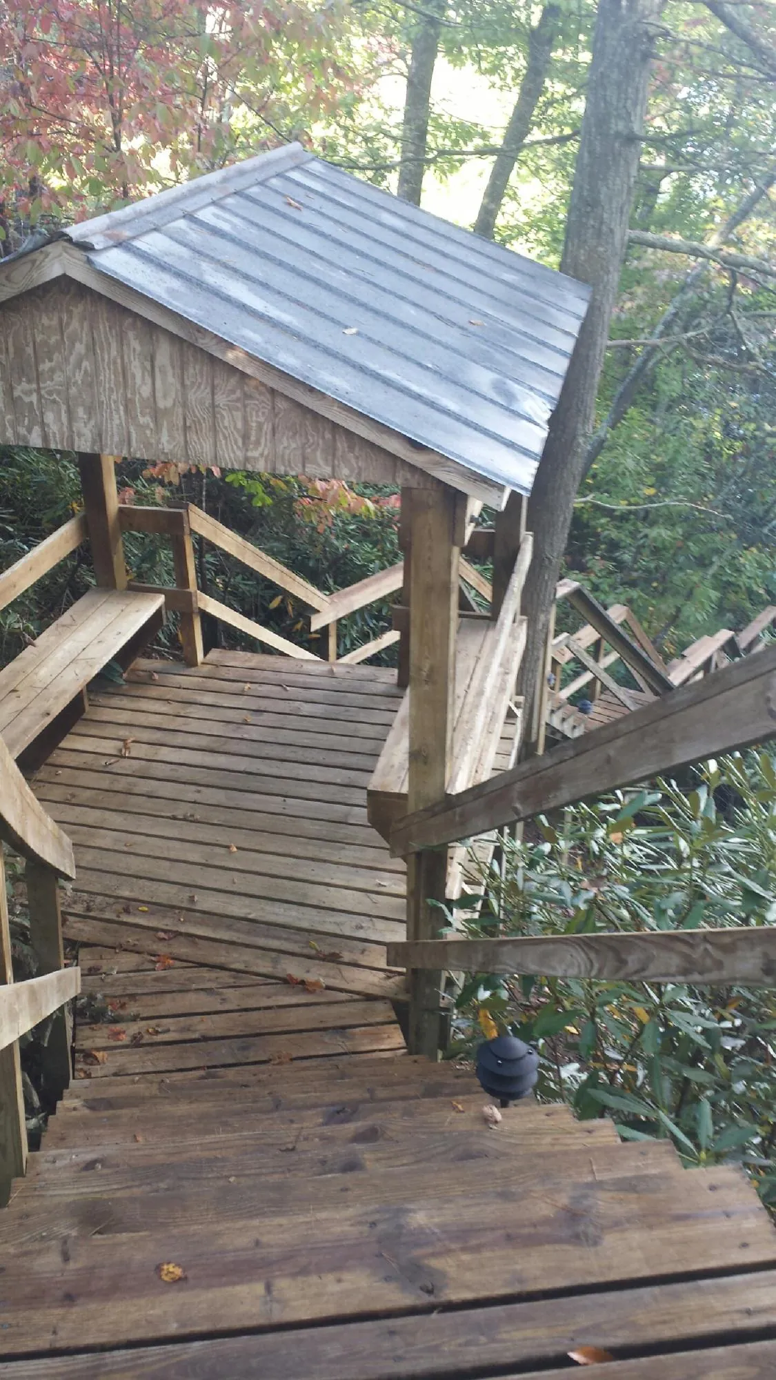 Metal roofed shelter over wooden steps on a wooded walkway — Skylight Repair & Installation work by our crew in Streetsboro